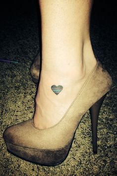 a woman's foot with a small heart tattoo on her left side calfocks