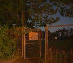 a fence with a sign on it at night