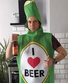 a person in a green costume holding a beer and giving the thumbs up with both hands