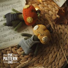 three crocheted stuffed animals sitting on top of a basket next to sheet music