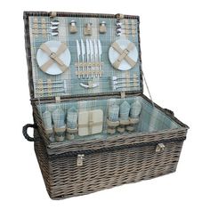 a wicker picnic basket with utensils and plates in the lid, on a white background