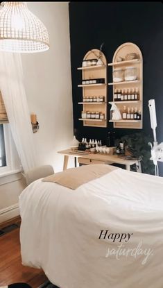 a room with a bed, desk and shelves on the wall that have bottles in them