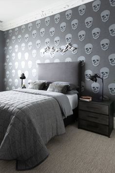 a bedroom with skulls painted on the wall and a bed in front of a night stand