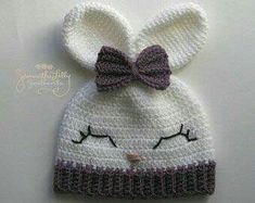 a crocheted bunny hat with a bow on it's head and ears