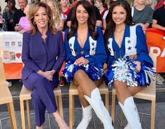 two women in cheerleader outfits are sitting on wooden chairs and smiling at the camera