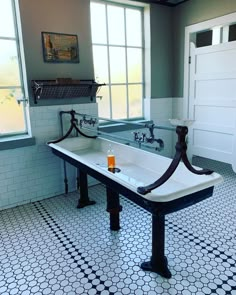 a bathroom with two sinks and a bathtub in the middle of the floor is black and white