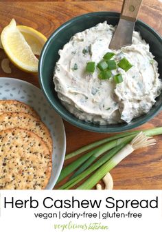 hummus, crackers and lemon wedges on a wooden table with a bowl of dip