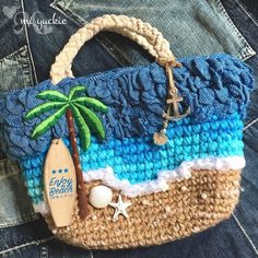 a purse with a palm tree, starfish and beach ball on it sitting in someone's jeans pocket