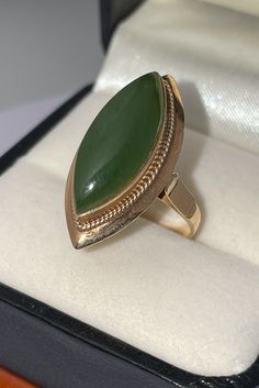 Beautifully vintage statement ring. Solid, stamped 14K Yellow Gold. Intricately detailed gallery work features a genuine Nephrite Jade gem. Ring size approximately 6.25. According to the Jade Hunt site, "Nephrite jade has been revered for thousands of years for its symbolism and cultural significance. It has been associated with various meanings, such as protection, prosperity, and good luck. Nephrite jade is believed to possess healing properties and spiritual meaning, often associated with the heart chakra. It is said to promote emotional balance, attract love, and encourage forgiveness." Good Fortune Jade Rings, Heirloom Green Oval Cabochon Jewelry, Yellow Gold Jade Cabochon Ring, Heirloom Green Cabochon Jewelry, Elegant Jade Cabochon Rings, Elegant Jade Rings With Cabochon, Vintage Gold Emerald Cabochon Ring, Antique Yellow Gold Cabochon Emerald Ring, Antique Yellow Gold Emerald Cabochon Ring