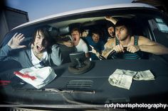 a group of young men sitting in the back of a car with their mouths open