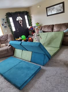 a child is playing in the living room with two large pieces of furniture on the floor