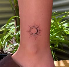 a woman's foot with a small tattoo on the side of her leg and sun in the middle