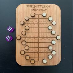 a wooden board game with two dices and the battle of marathon written on it