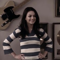 a woman standing in front of a guitar