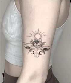 a woman's arm with a sun and flowers tattoo on the left side of her body