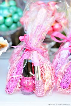 two bags filled with pink and white items sitting on top of a table next to candy