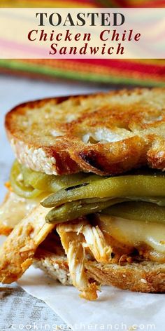 a grilled chicken sandwich with pickles, cheese and onions on toasted bread