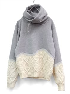 a gray and white sweater hanging on a hook