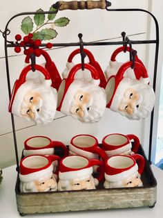 santa claus mugs are hanging from a rack