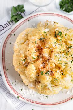 a plate topped with cauliflower covered in parmesan cheese and seasoning