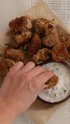 a person dipping something into a bowl with some kind of sauce on top of it