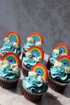 cupcakes with blue frosting and rainbow decorations