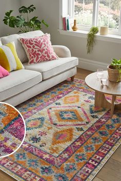 a living room with white couches and colorful rugs