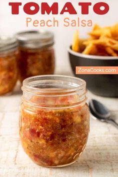 a jar filled with food sitting on top of a table next to a bowl of fries