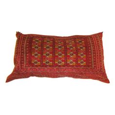 a red and yellow decorative pillow on a white background