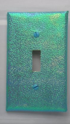 a green light switch cover with blue dots on it