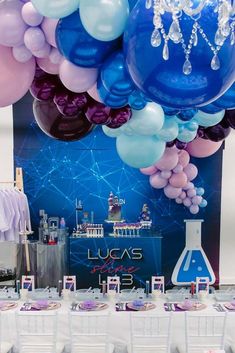 balloons are hanging from the ceiling above a table with desserts and drinks on it