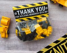 construction themed thank you cards with yellow and black legos on the ground next to them