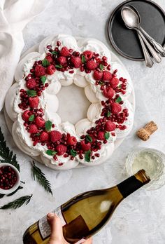 a cake decorated with raspberries and white frosting on top of a table