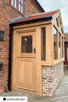 a wooden building with an open door on the outside and brick wall around it,