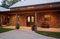 a brick house with two large planters on the front porch and an entry way