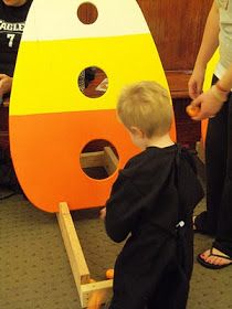 a little boy standing next to a wooden toy rocket ship