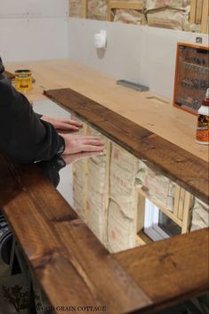 a person sitting at a counter with woodworking plans