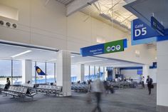 people are walking through an airport terminal with luggage and signs on the walls that read, care d5