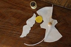 sewing supplies are laid out on a wooden table, including thread and paper cutouts