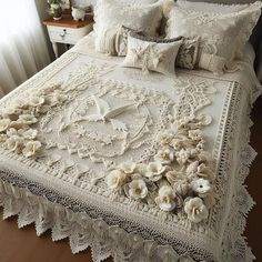 a bed with white lace and flowers on it