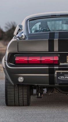 the rear end of a black and gray sports car