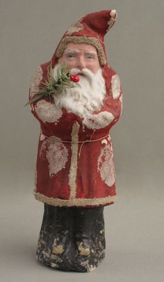 a santa clause figurine holding a plant in his hand