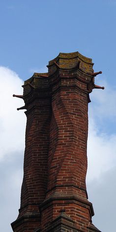 an old brick tower with a clock on it's side against a blue sky