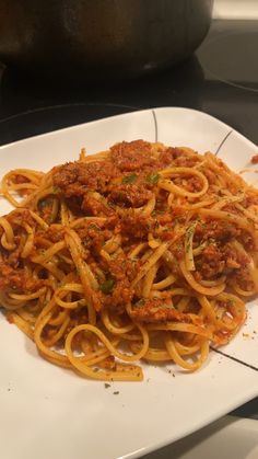 spaghetti with meat sauce and parsley on a white plate