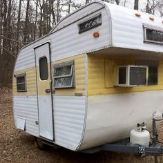 an old trailer is parked in the woods