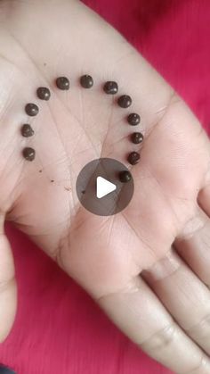 a person's hand with tiny black balls on it and the thumb pointing up