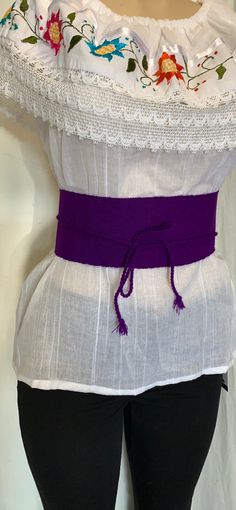 "Discover the allure of our exquisite Mexican Faja, a symbol of timeless chic. Crafted with precision, this belt is a canvas of beauty, adding a pop of color to any ensemble. Key Features: Color: Purple Size: Fits Most Sizes Belt Dimensions: Width: 3 3/4\" Length: 29.5\" Braided Section: 25\" Additional Details: Embroidery: Traditional Mexican embroidery adds a touch of artistry. Folk Fabric Flowers enhance the belt's cultural charm. This 100% authentic Mexican belt is more than an accessory; it's a piece of living tradition. Whether you're looking to add flair to your outfit or celebrate Mexican craftsmanship, this gorgeous green belt is a perfect choice. Elevate your style with the vibrant allure of our Beautiful Solid Color Mexican Faja." Elegant Fabric Beach Belt, Elegant Fabric Belt For Beach, White Fabric Belt For Summer, Elegant Fabric Belt For Summer, Elegant Summer Fabric Belt, Elegant Embroidered Summer Belt, Elegant Belts For Beach, White Adjustable Fabric Belt, Mexican Belt