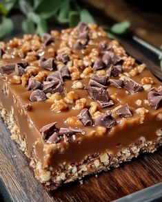 a piece of chocolate and nuts bar sitting on top of a wooden cutting board