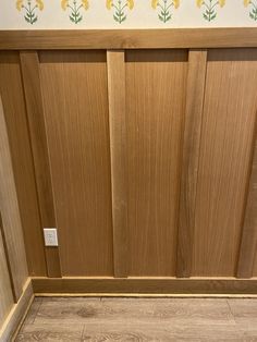 a bathroom with wooden doors and tile flooring next to a white toilet in the corner