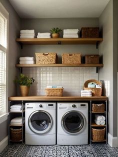 a washer and dryer in a small room with shelves on the wall above them